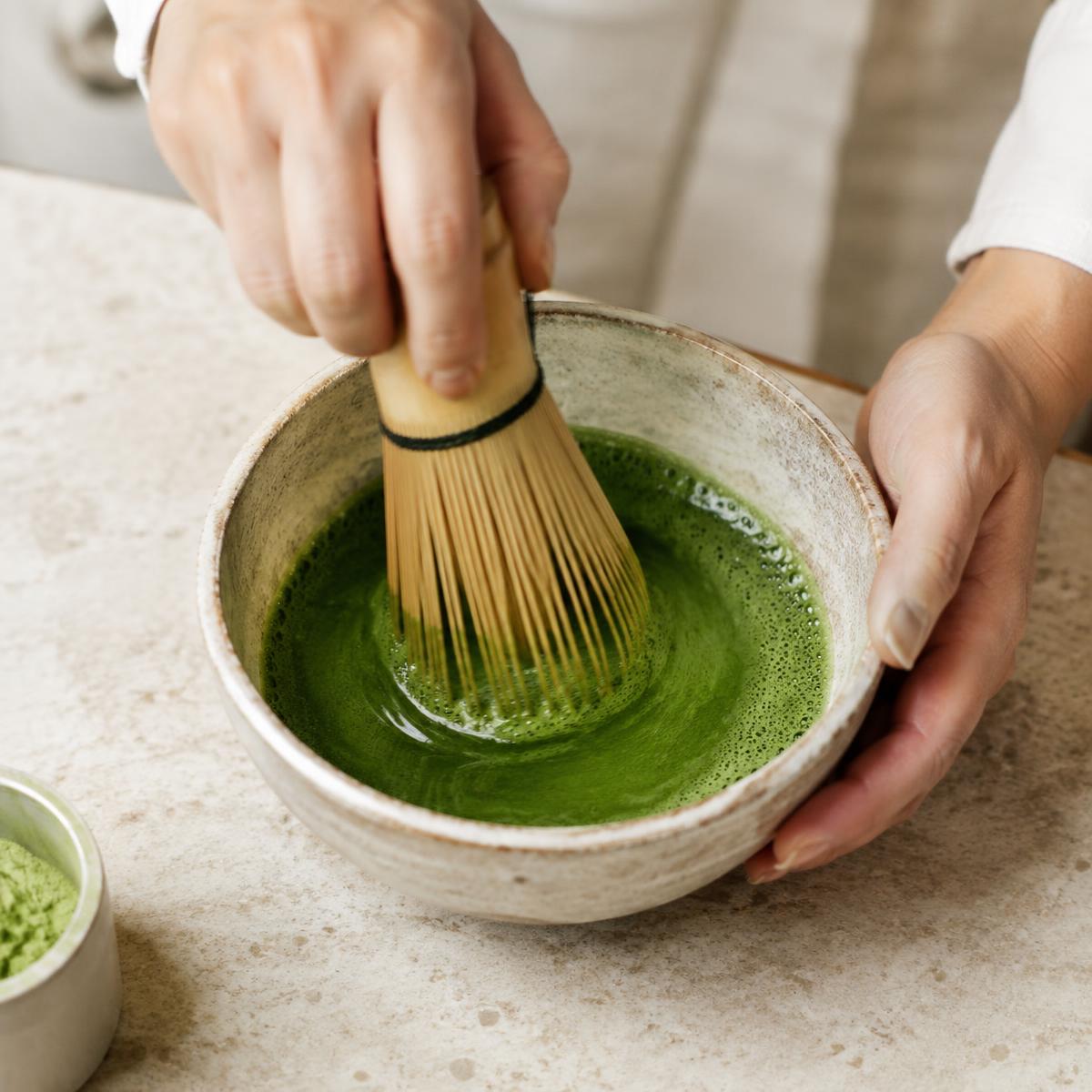 Matcha shot being whisked for a layered drink